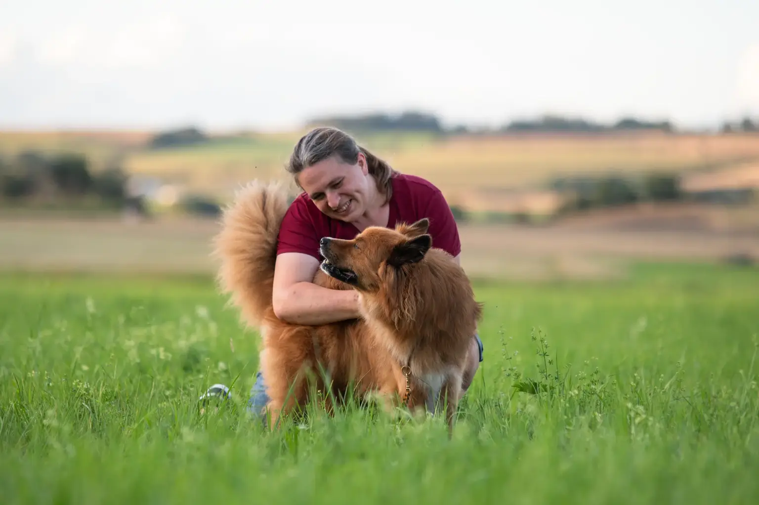 Theresa von der Halsbandflechterei kuschelt mit ihrem Hund Bruno.