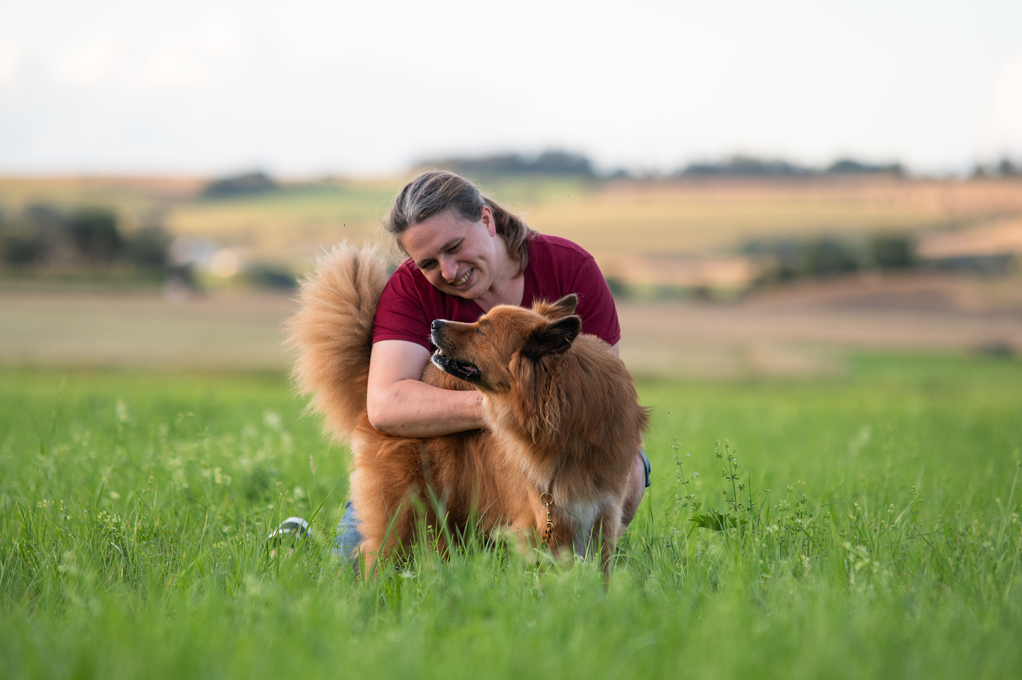 Theresa von der Halsbandflechterei kuschelt mit ihrem Hund Bruno.
